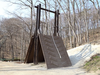 外で木製で作られた遊具とロープがぶら下がっている写真