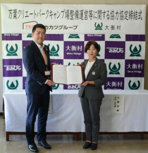 男性と女性が互いに書状を持ち合っている写真