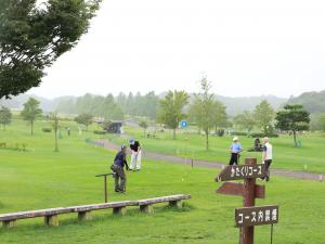 外で大人たちが集まり芝生が一面に見える写真