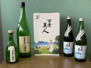 中央に「万葉美人」と書かれた箱が置いてあり、その周りに大小の酒瓶が並んでいる写真