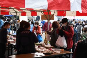 屋台でお客さんが買い物をし、袋を受け取っている写真