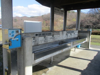 水道精算機の横に並んでいる水道の蛇口の写真