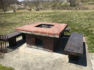 外でレンガで組んだ野外炉と芝生が写っている写真