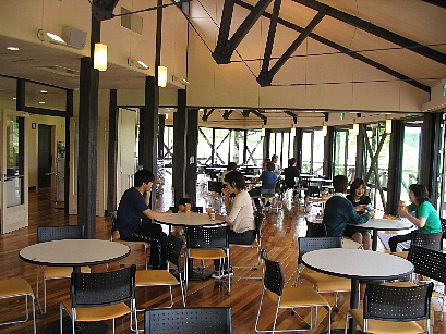 屋内の交流館で丸テーブルを囲みながら談笑している利用客の様子