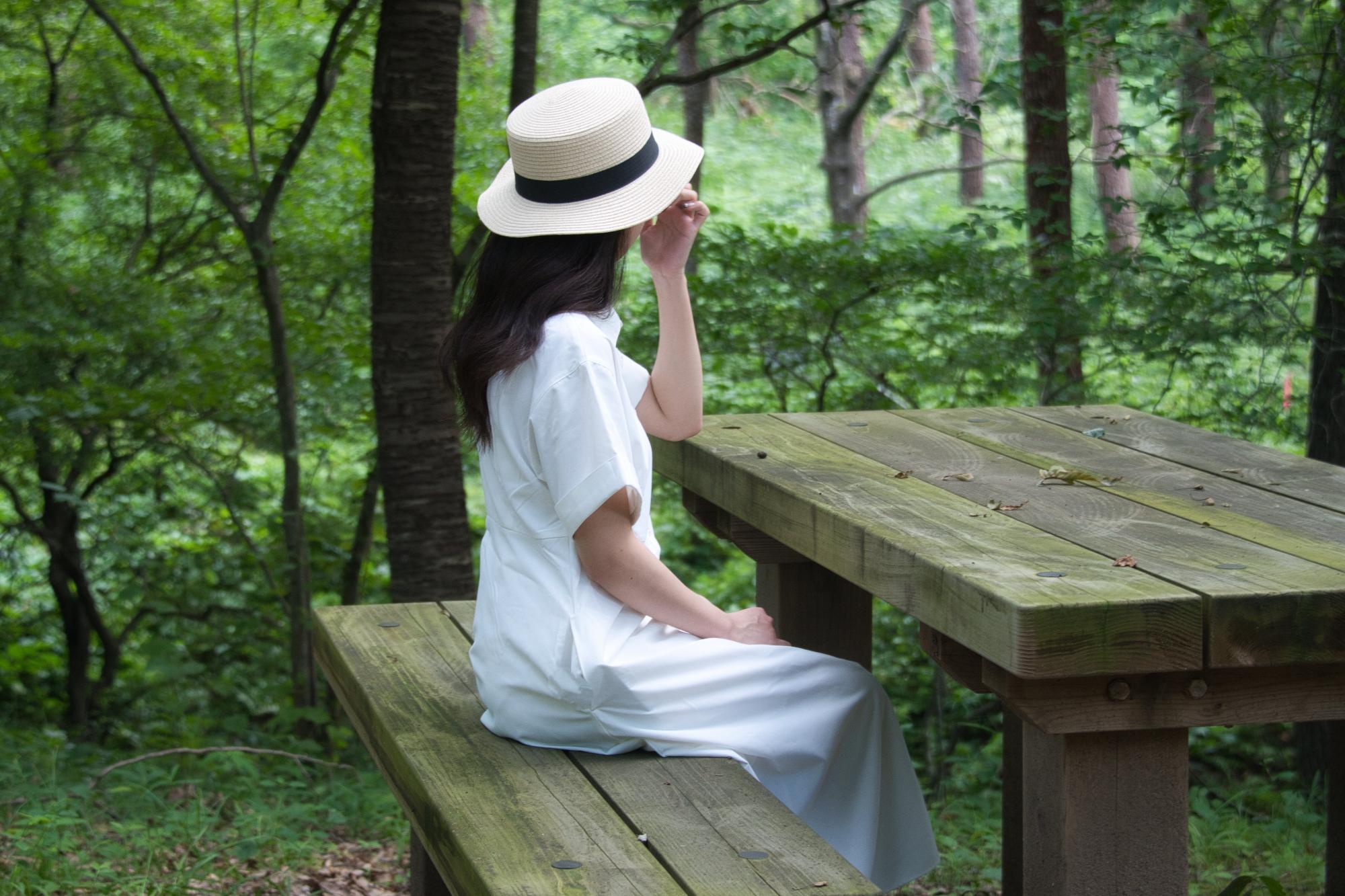 昭和万葉の森のベンチに座る女性